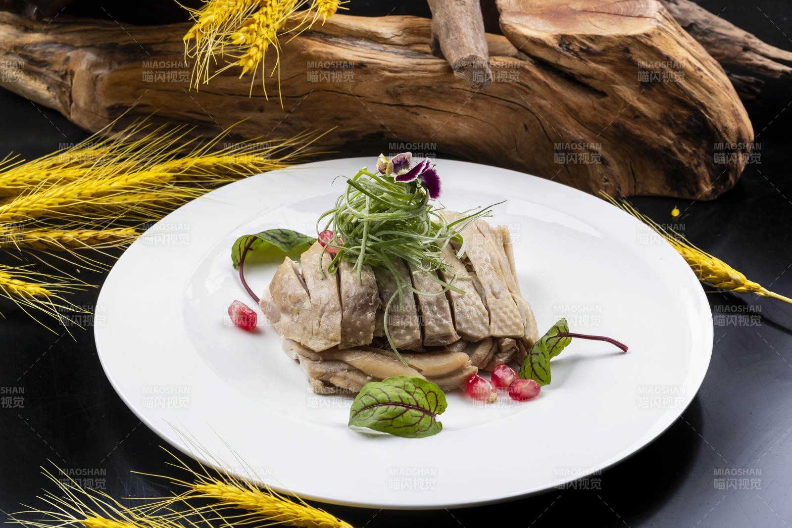 圆形瓷盘装的白斩鸡摆放在黑色背景上图片