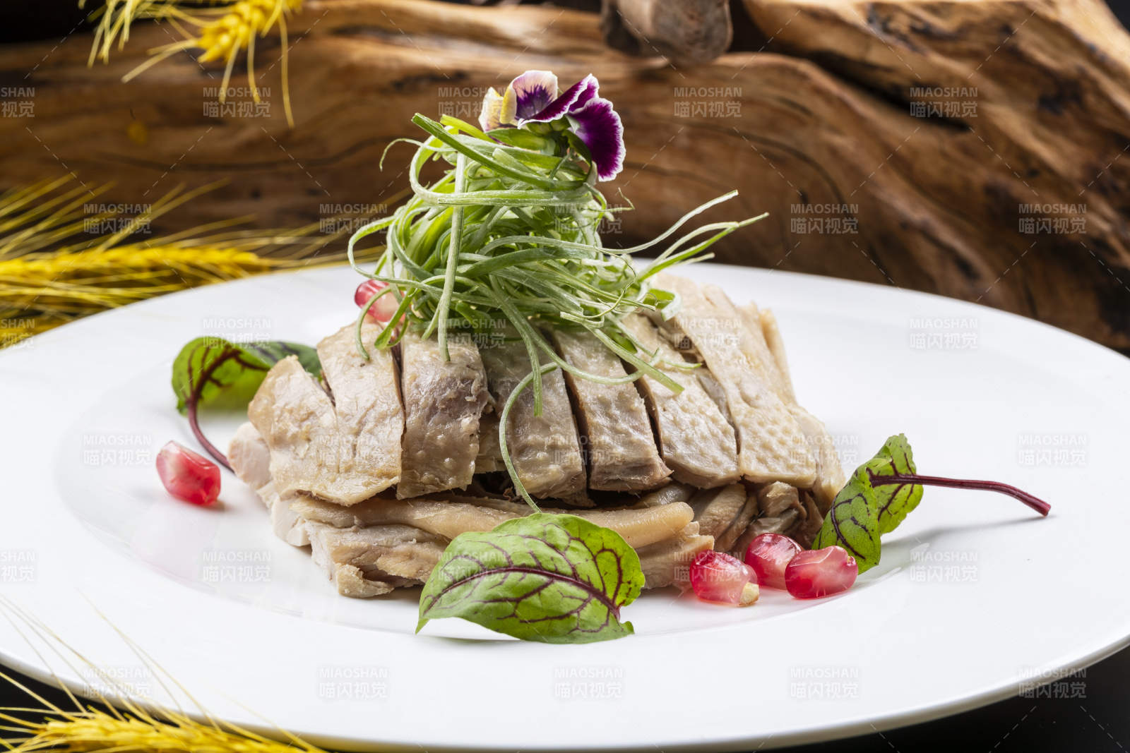 圆形瓷盘装的白斩鸡摆放在黑色背景上图片