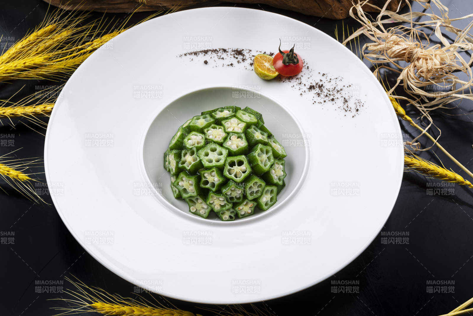 圆形瓷盘装的捞汁鲜秋葵摆放在黑色背景上图片