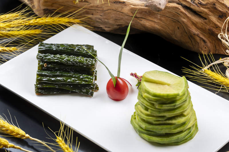 乳瓜拼青萝卜摆放在黑色背景上图片