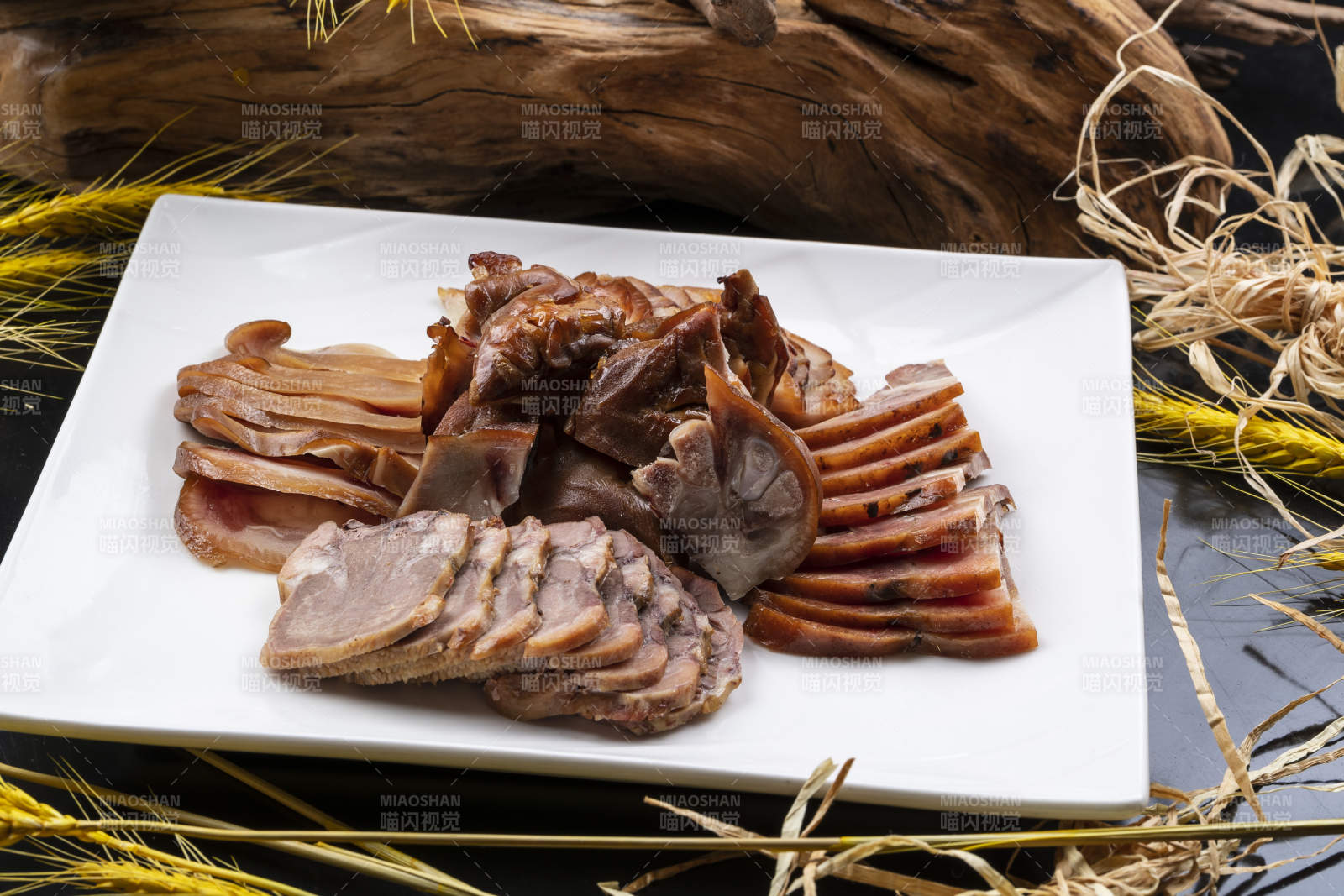 方形瓷盘装的卤肉拼盘摆放在黑色背景上图片