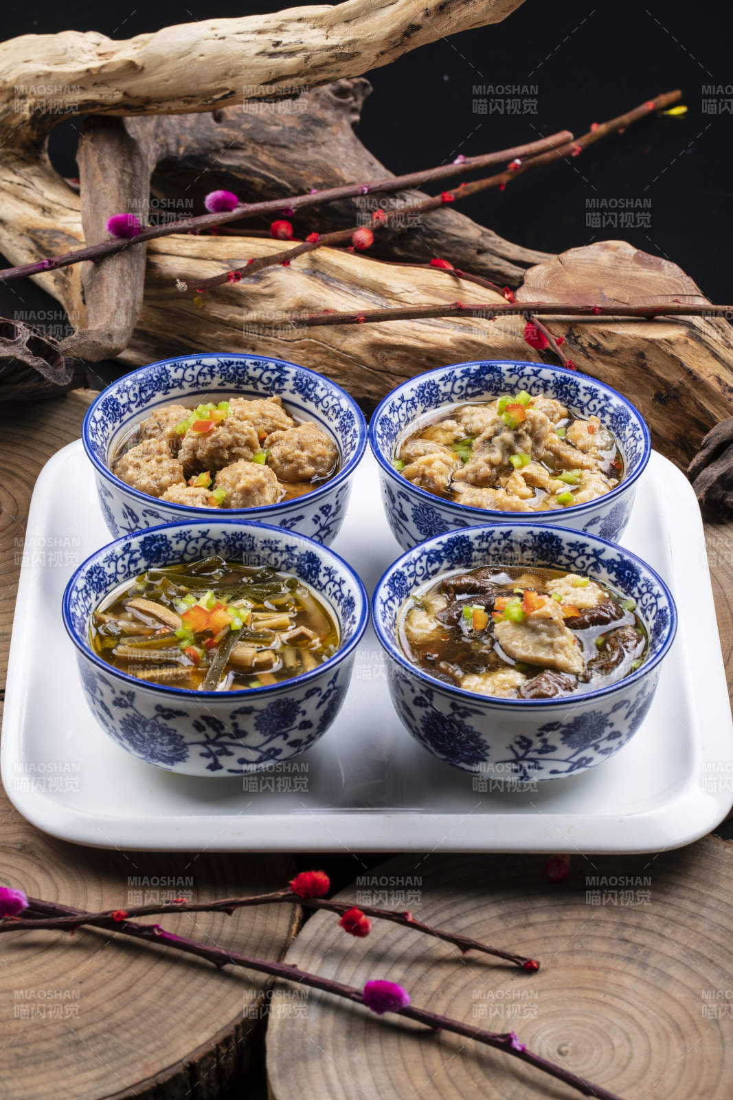 青花瓷碗装的传统四大碗摆放在樟木砧板上图片