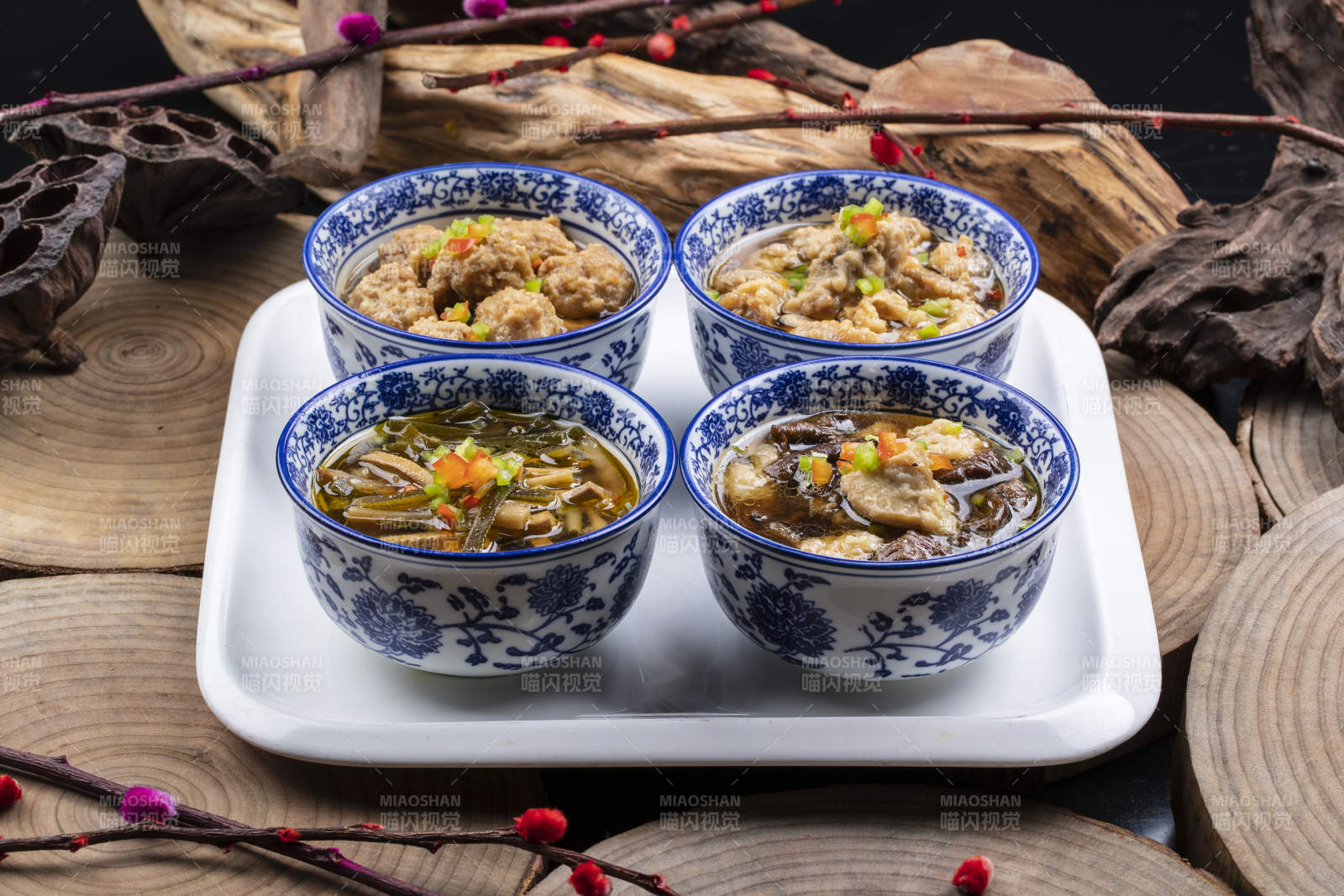 青花瓷碗装的传统四大碗摆放在樟木砧板上图片