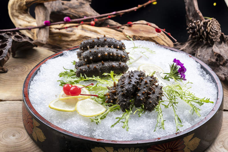 梅花参刺身摆放在樟木砧板上图片