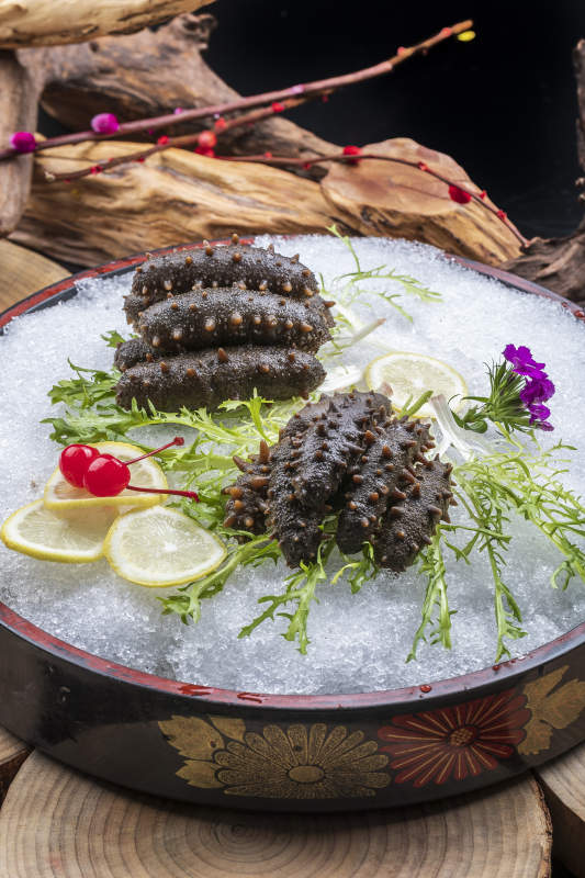 梅花参刺身摆放在樟木砧板上图片