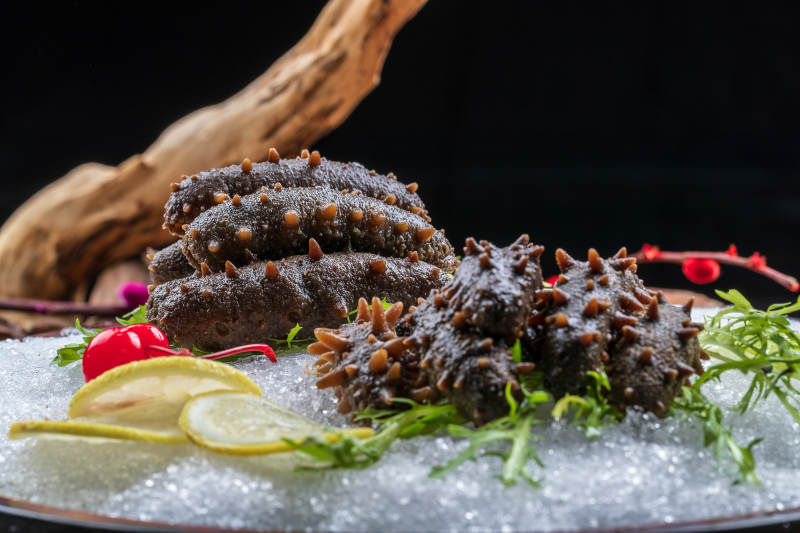 梅花参刺身摆放在樟木砧板上图片