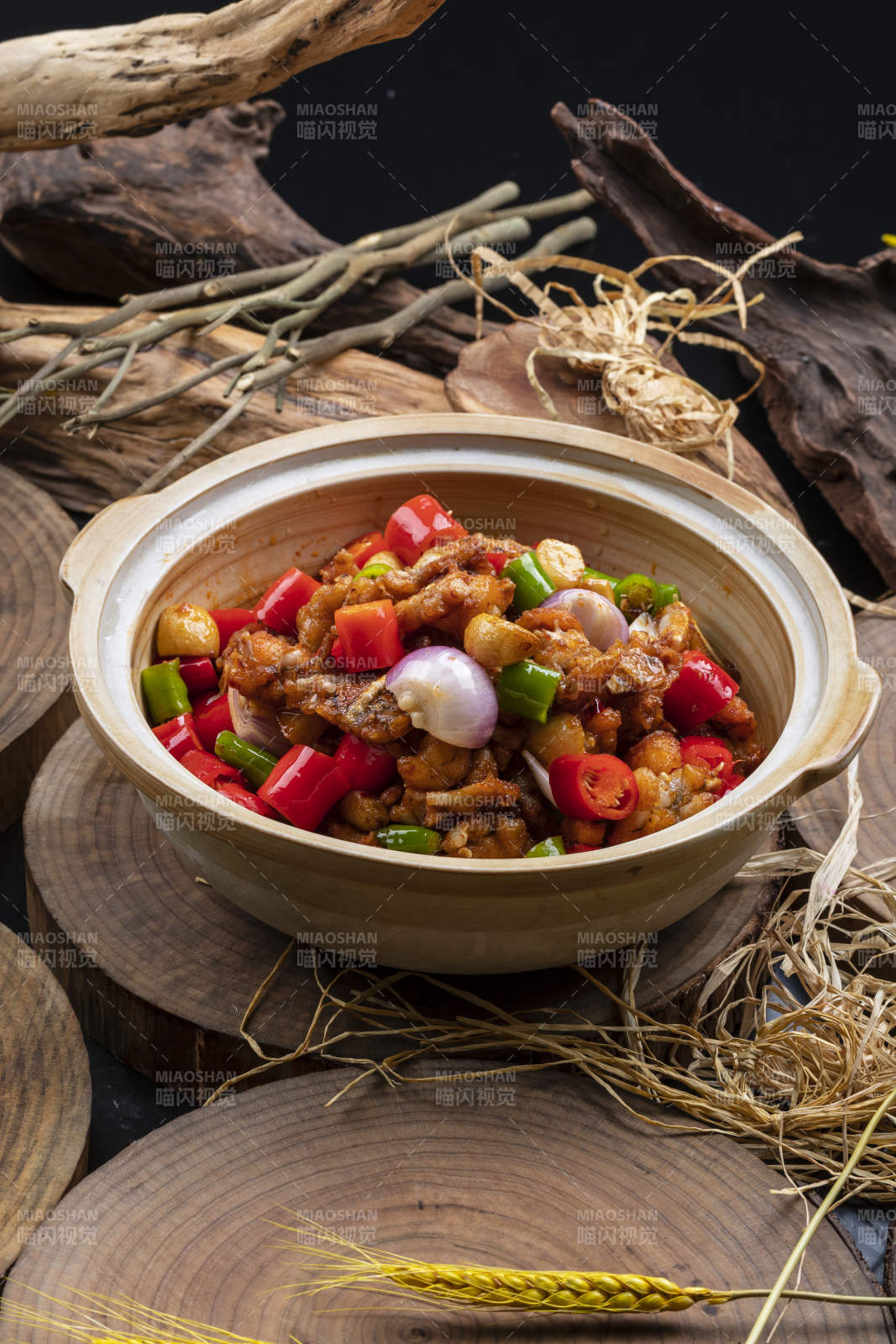 麻辣蒜香牛蛙煲摆放在樟木砧板上图片