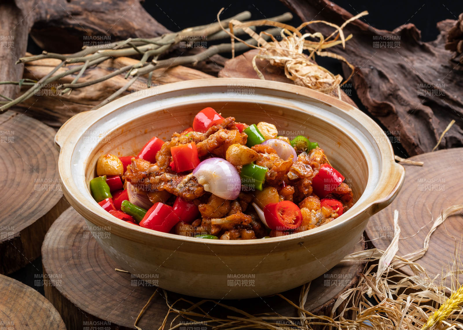 麻辣蒜香牛蛙煲摆放在樟木砧板上图片