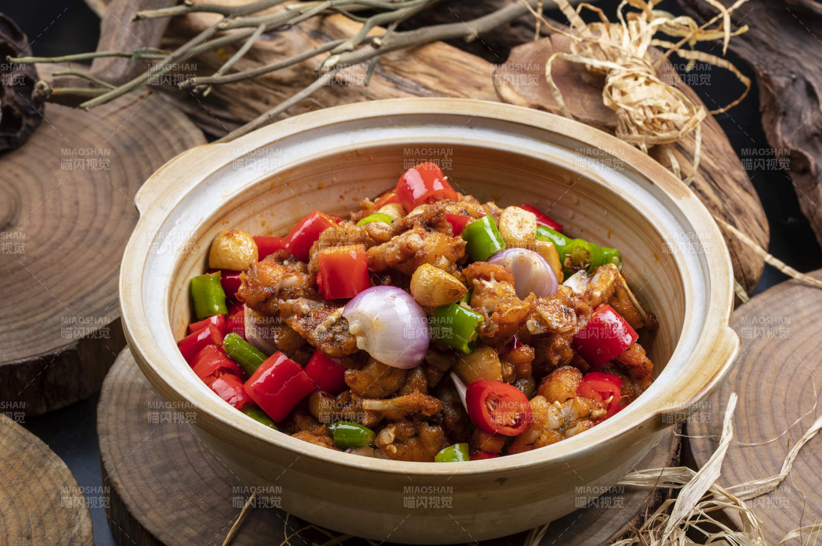 麻辣蒜香牛蛙煲摆放在樟木砧板上图片