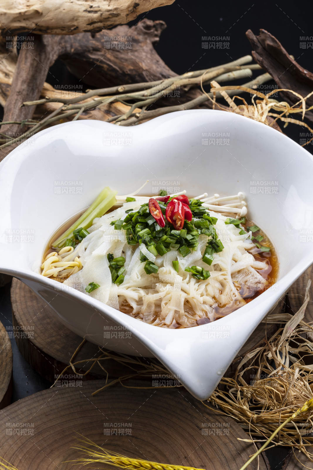 心型瓷盆装的晋味鸡汤凉皮摆放在樟木砧板上图片