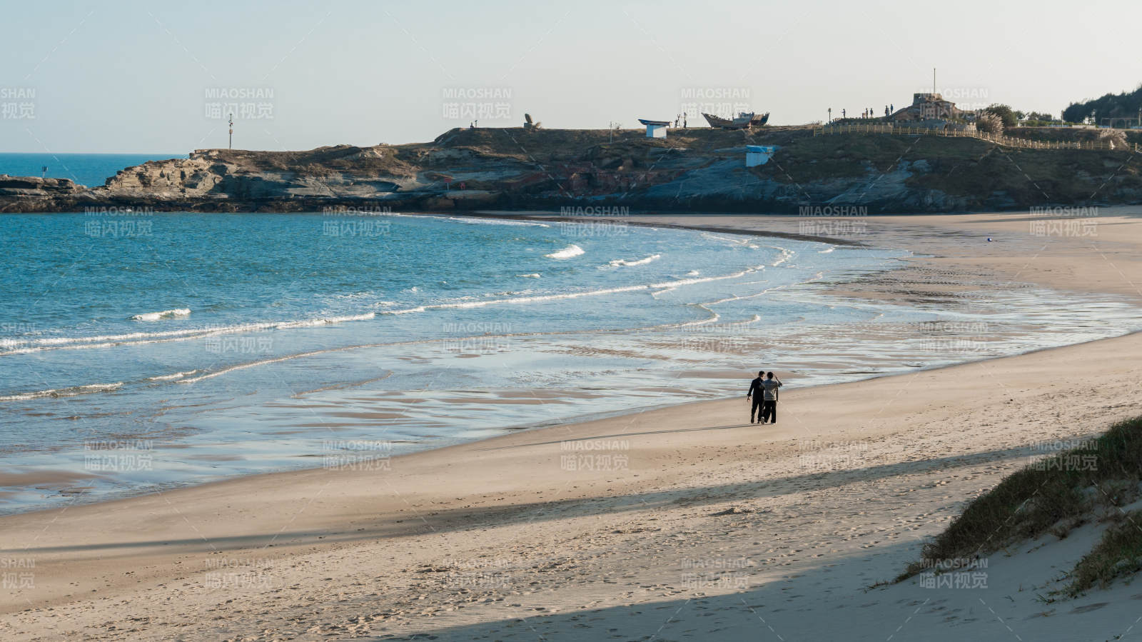泉州的海边散步的两人图片