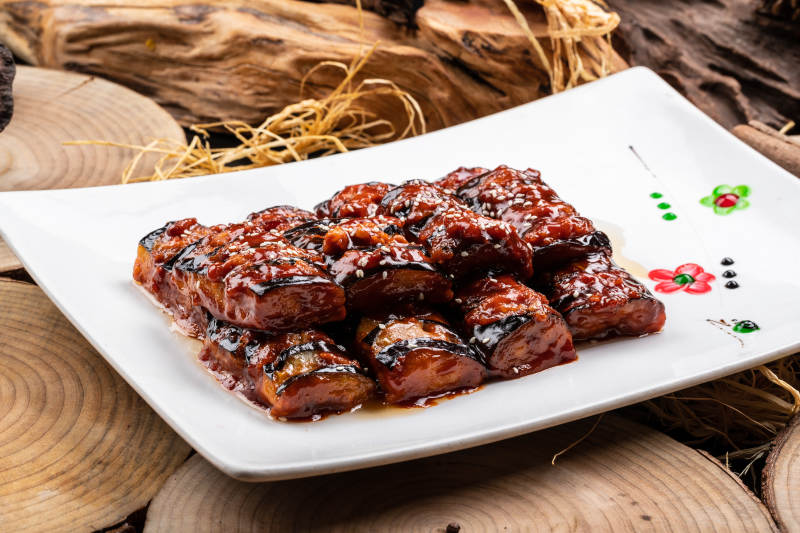 油煎肉末酱茄子摆放在樟木砧板上图片