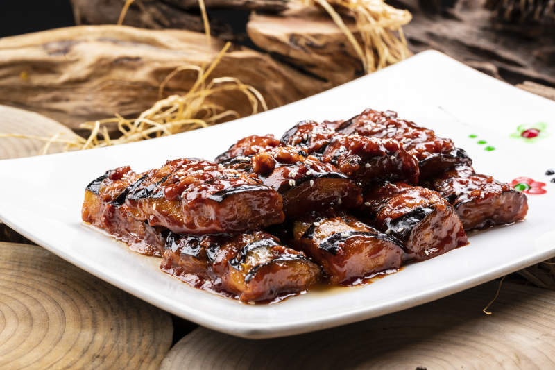 油煎肉末酱茄子摆放在樟木砧板上图片