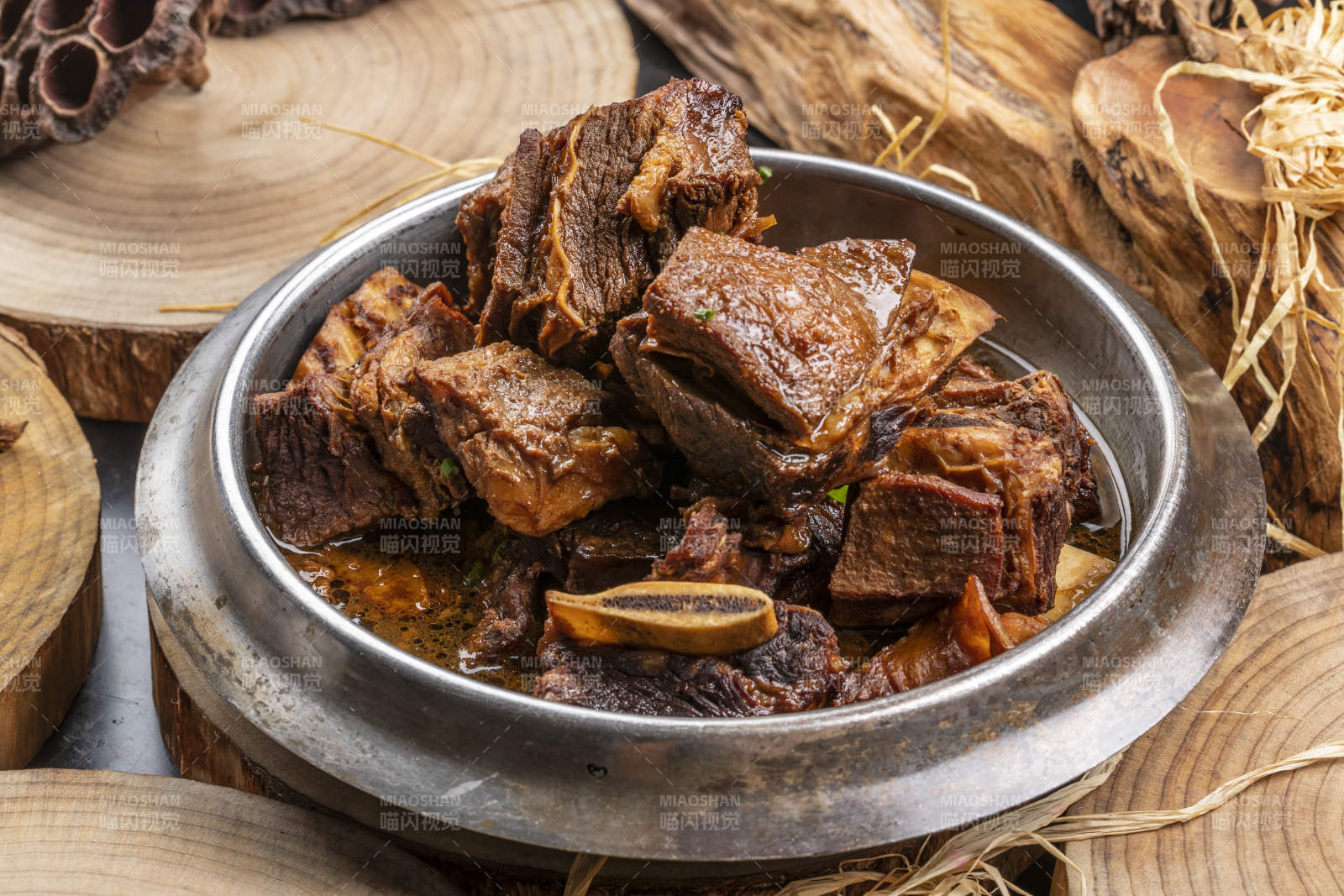 铁锅装的锅仔酱香肋排摆放在樟木砧板上图片