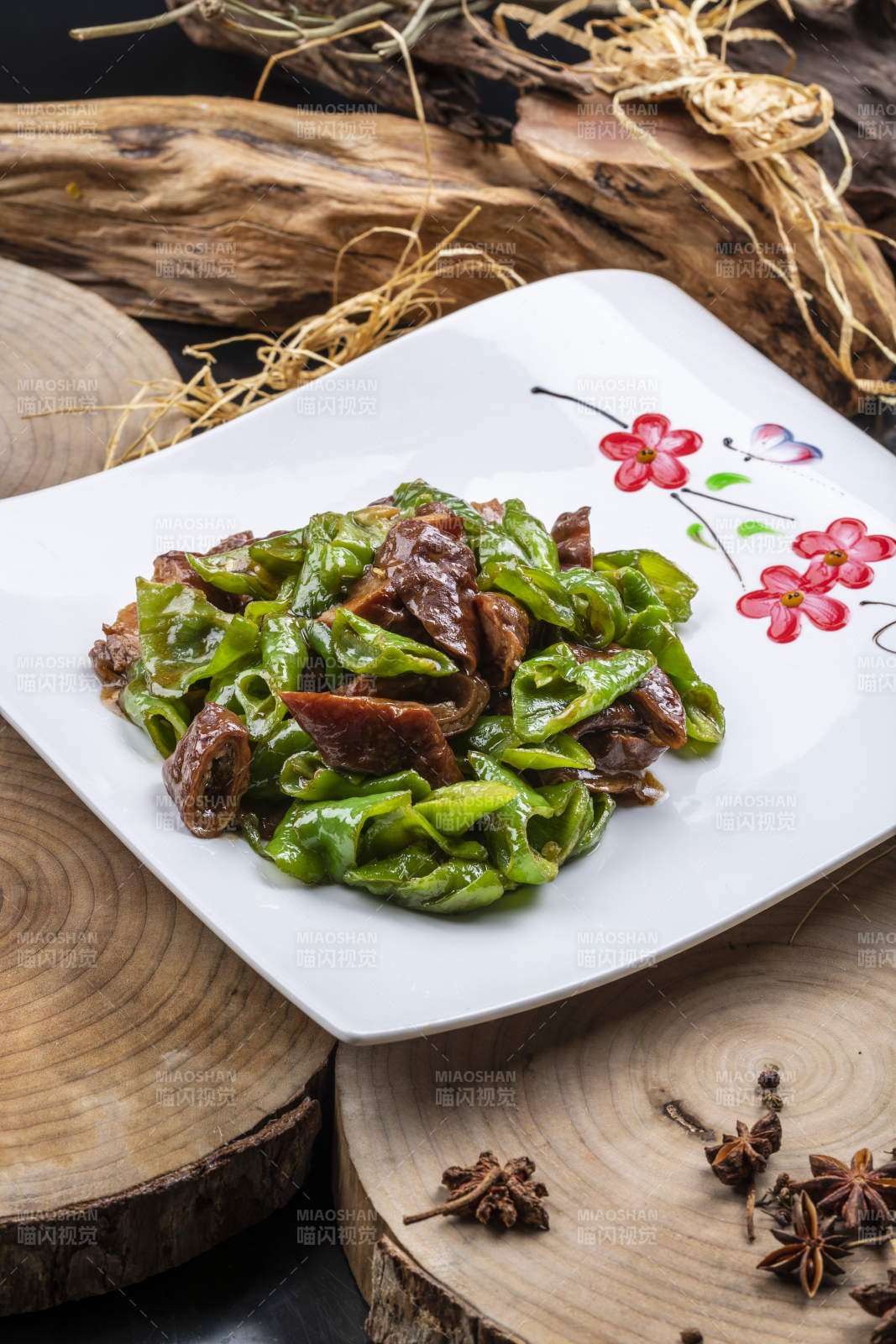 尖椒烧肥肠摆放在樟木砧板上图片