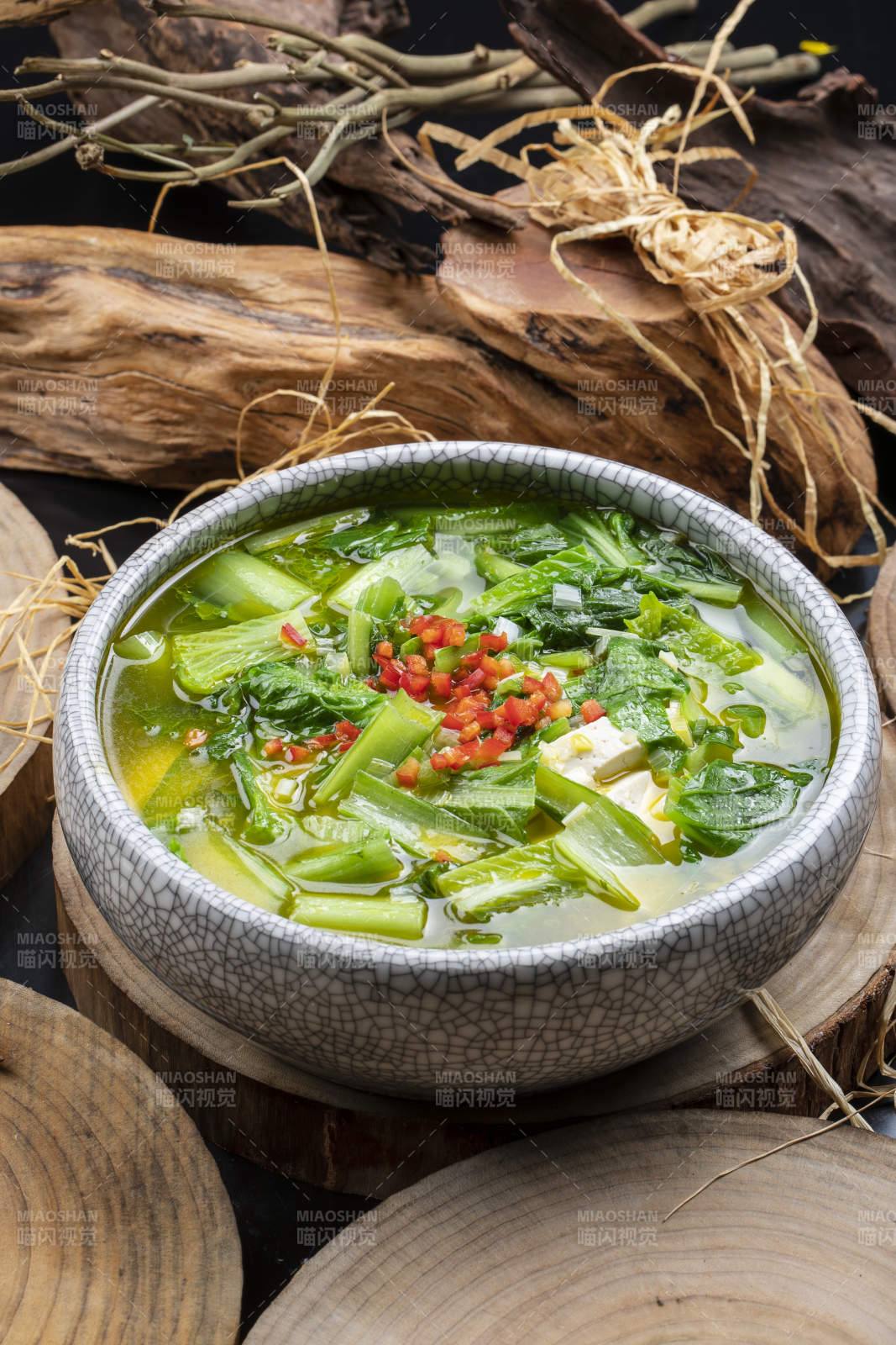 开片瓷碗装的小白菜烧豆腐摆放在樟木砧板上图片