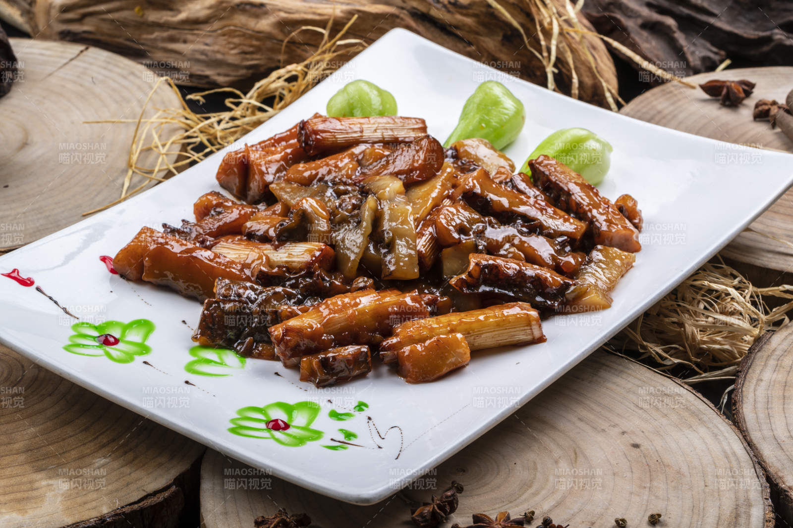 长方形花瓷盘装的葱烧皮参摆放在樟木砧板上图片