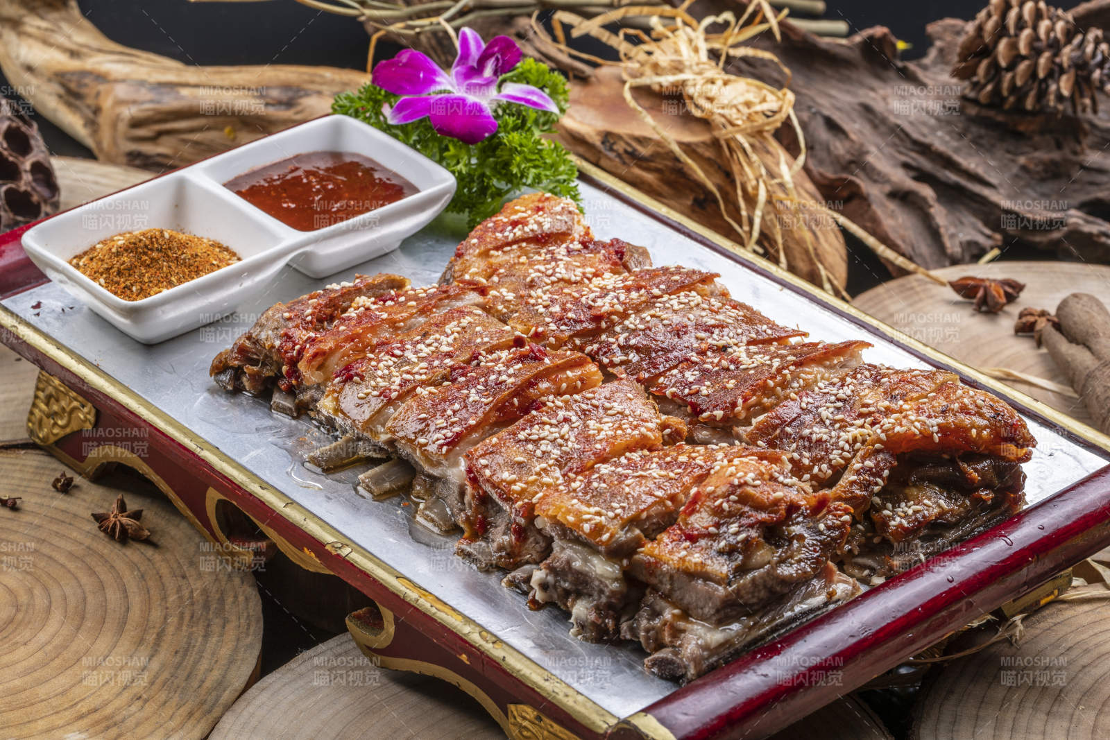 红色漆盘装的蒙古烤羊排摆放在樟木砧板上图片