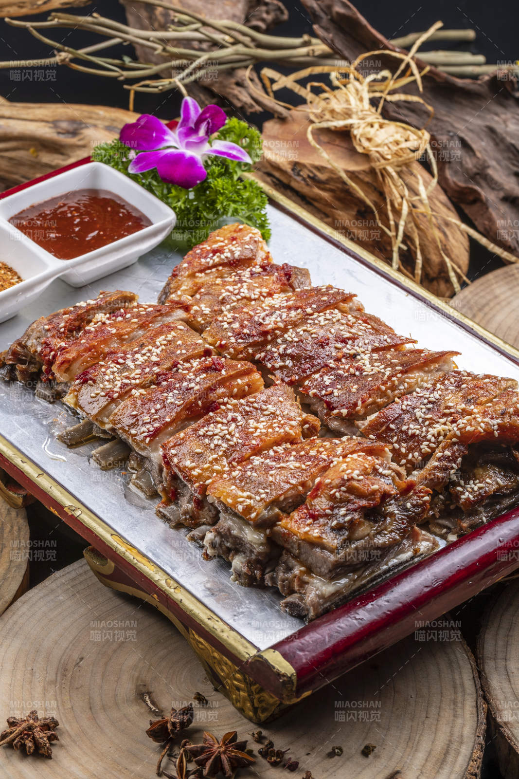 红色漆盘装的蒙古烤羊排摆放在樟木砧板上图片