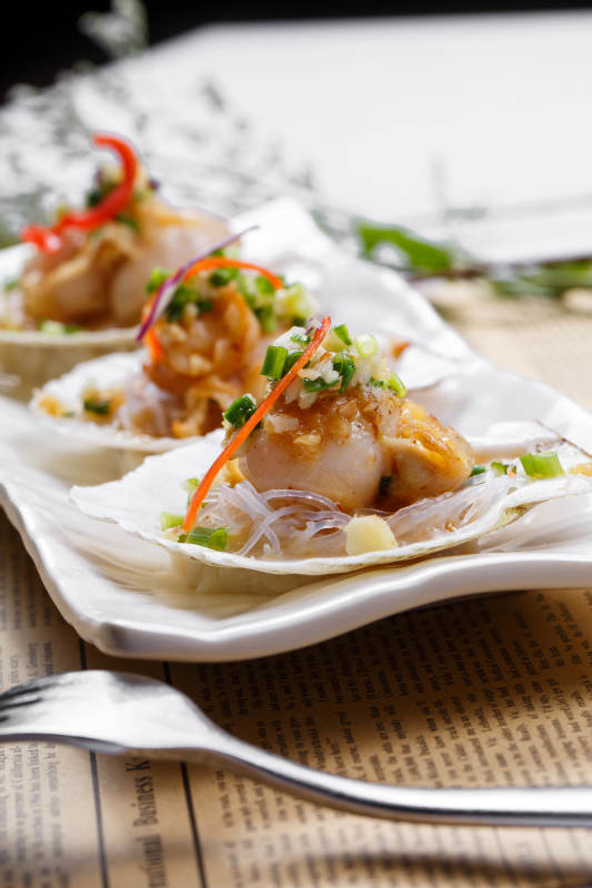 蒜蓉粉丝XO酱蒸扇贝摆放在英文包装纸上图片