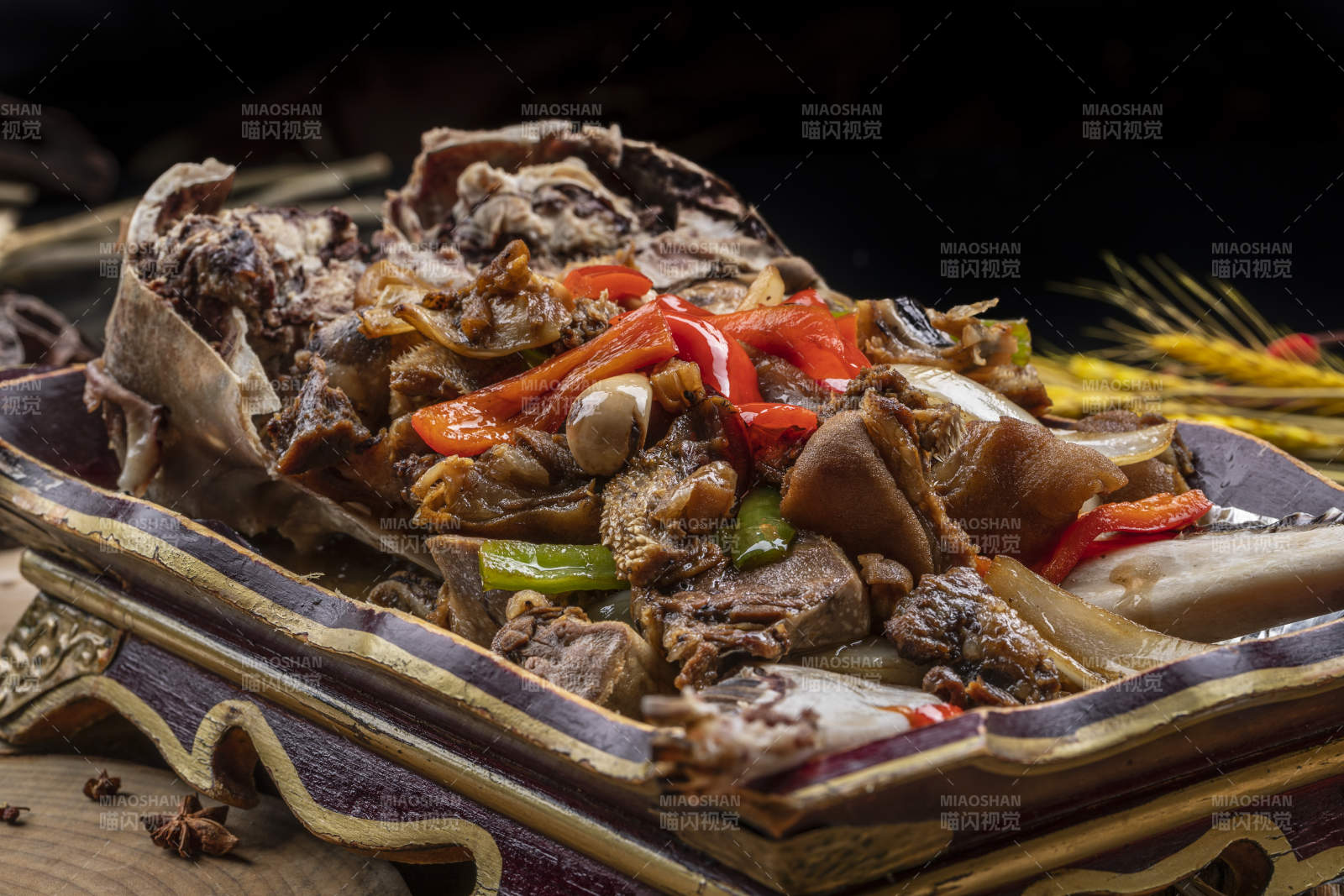 红漆木盘装的水煮蒜泥羊头摆放在樟木砧板上图片