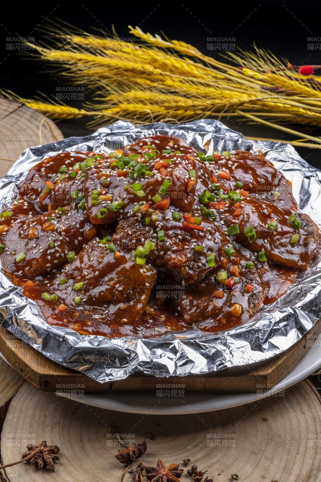 锡纸盘装的红烧脱骨带鱼摆放在樟木砧板上图片
