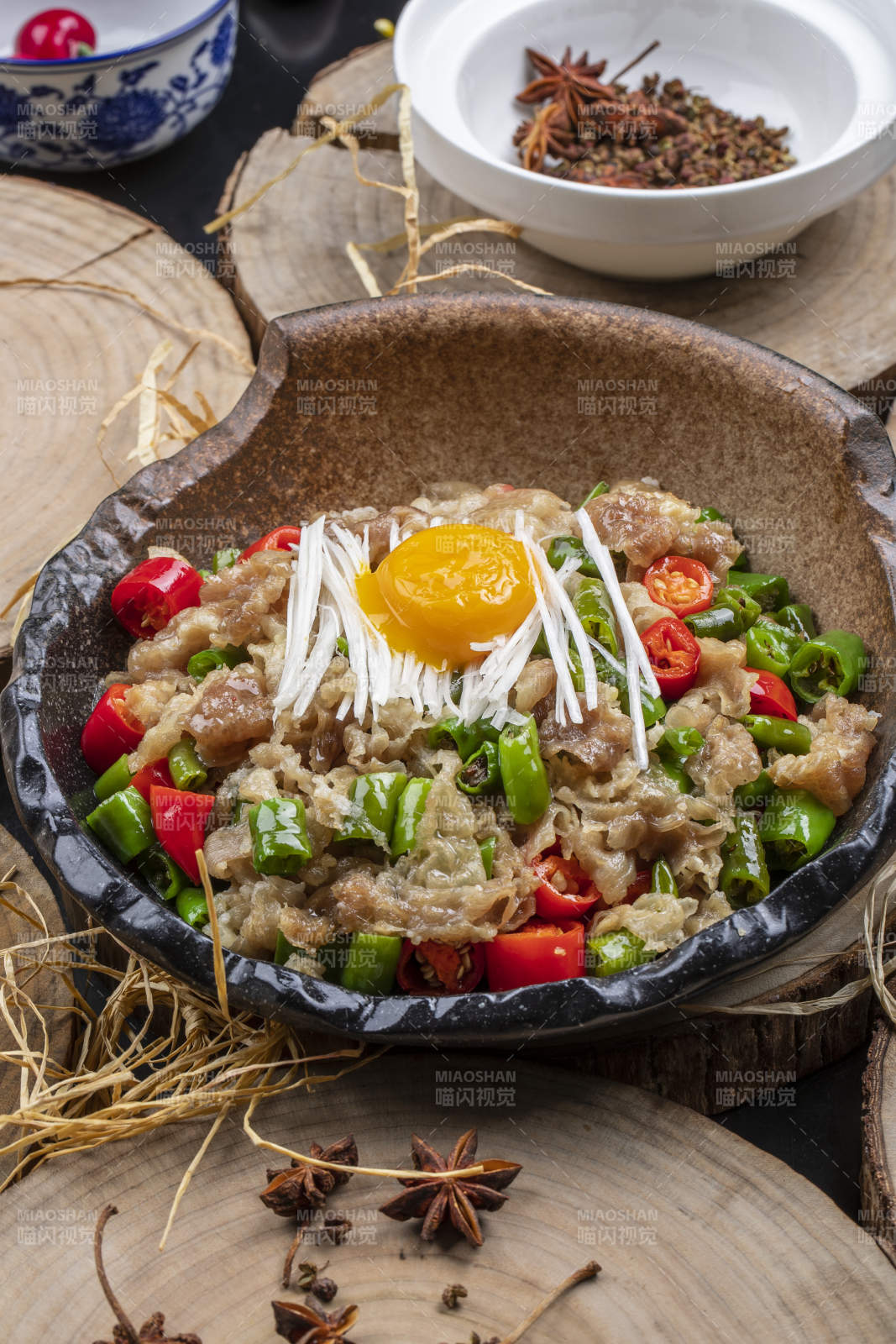 陶盘装的小米辣炒肥牛摆放在樟木砧板上图片