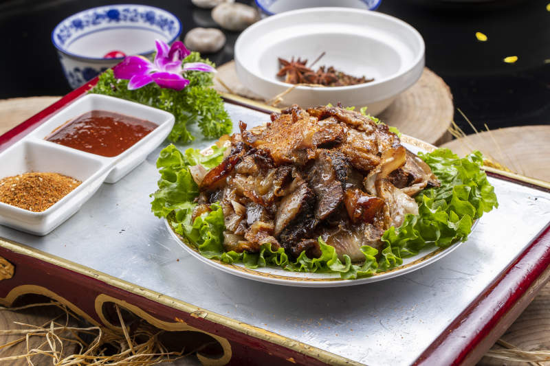 红漆木板装的分切全羊肉摆放在樟木砧板上图片