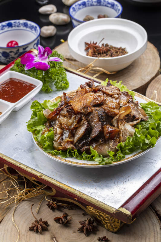 红漆木板装的分切全羊肉摆放在樟木砧板上图片