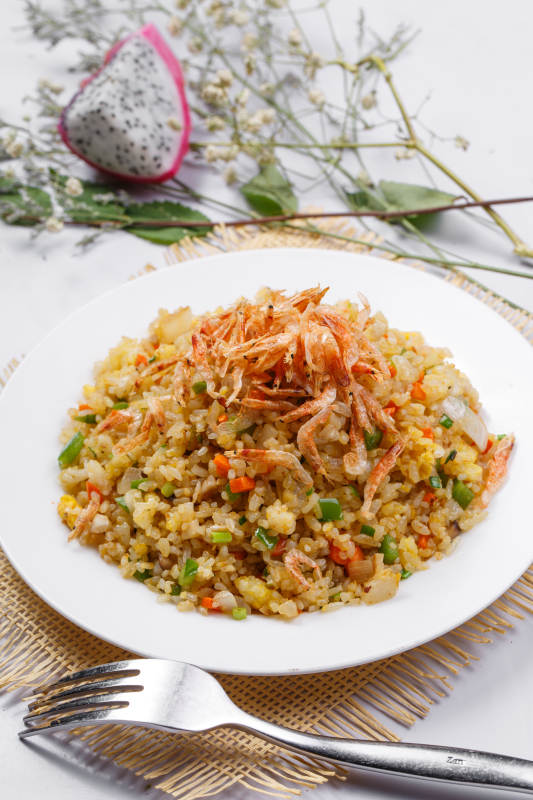 铁板虾干蛋炒饭摆放在草垫上图片