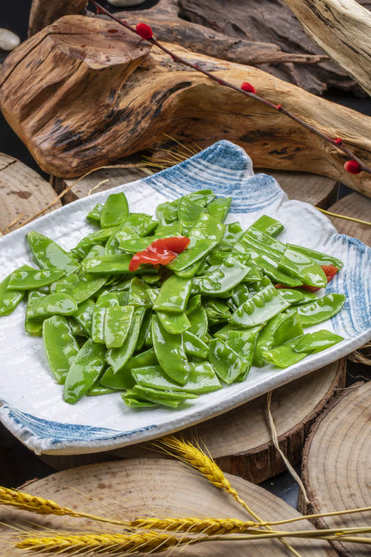 元瓷盘装的清炒时蔬蒜粒荷兰豆图片