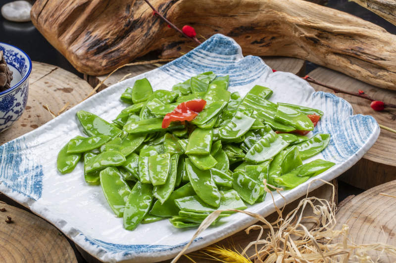 元瓷盘装的清炒时蔬蒜粒荷兰豆图片