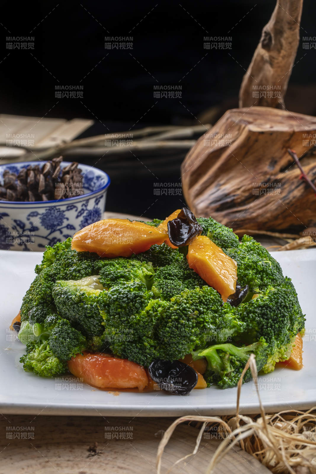 白色梅花瓷盘装的白灼西蓝花摆放在寿司帘上图片