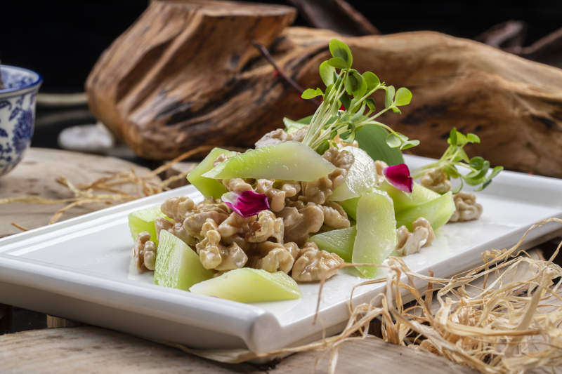 白瓷盘装的西芹鲜桃仁图片