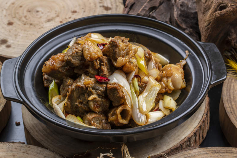 黑色砂锅装的砂锅大葱煲牛腱子肉图片
