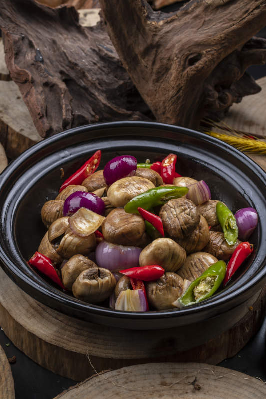 黑色砂锅装的小葱头鲜口蘑米椒煲图片