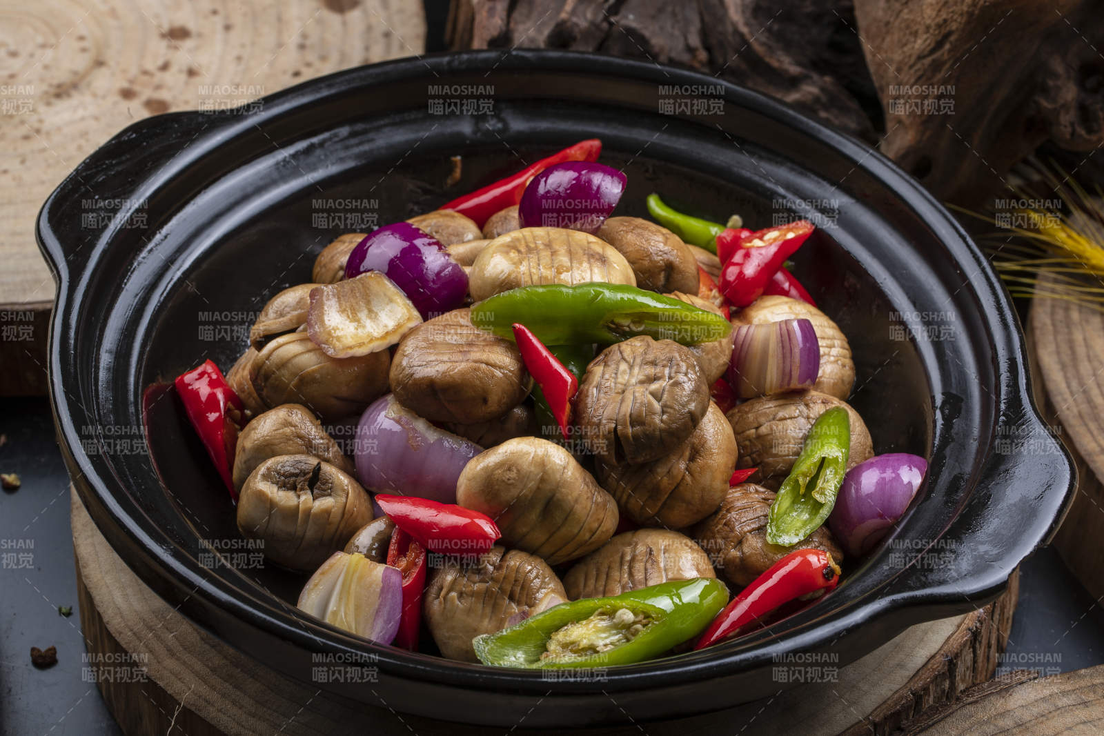 黑色砂锅装的小葱头鲜口蘑米椒煲图片