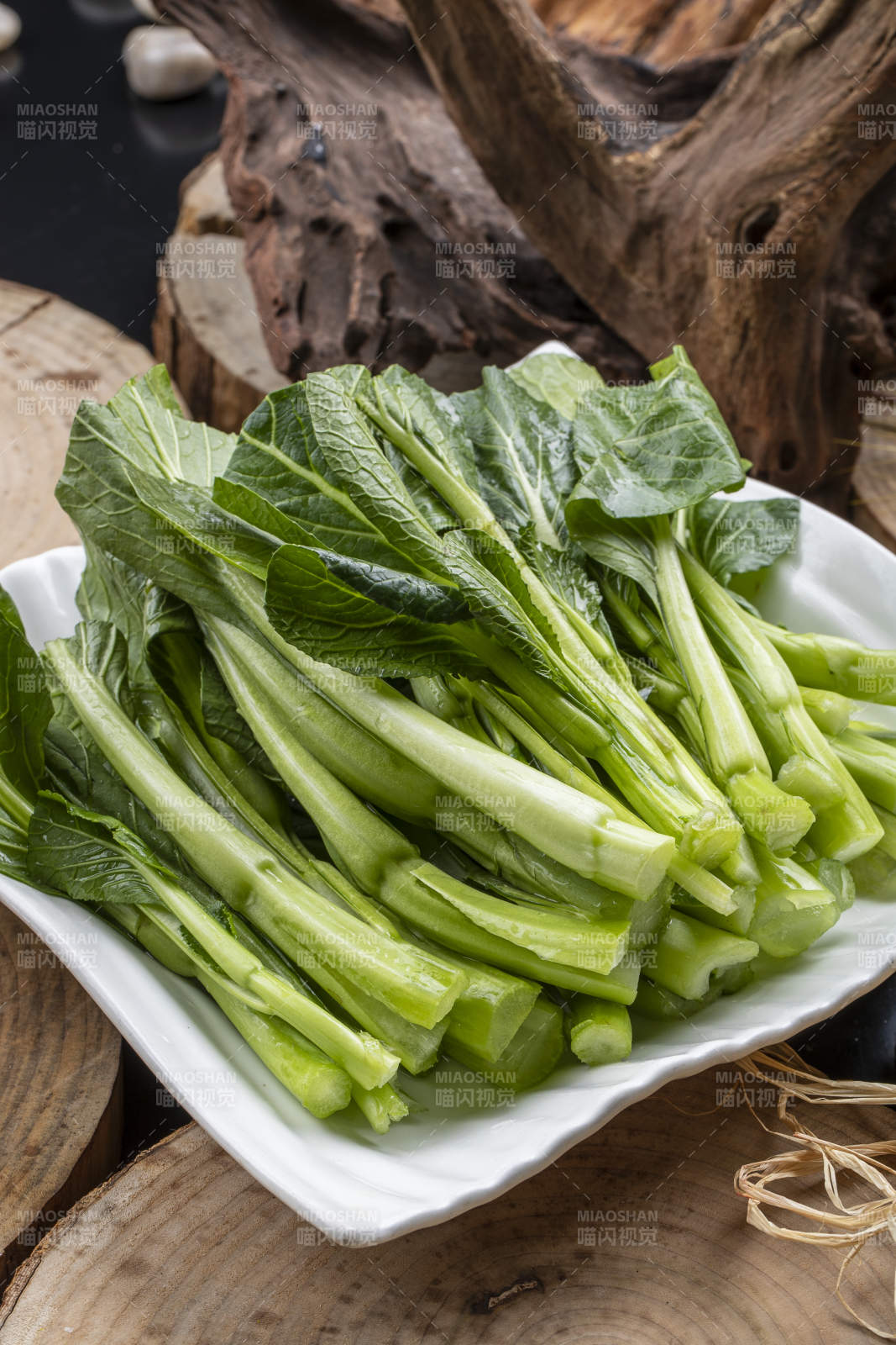 白色瓷盘装的生鲜新鲜菜心图片