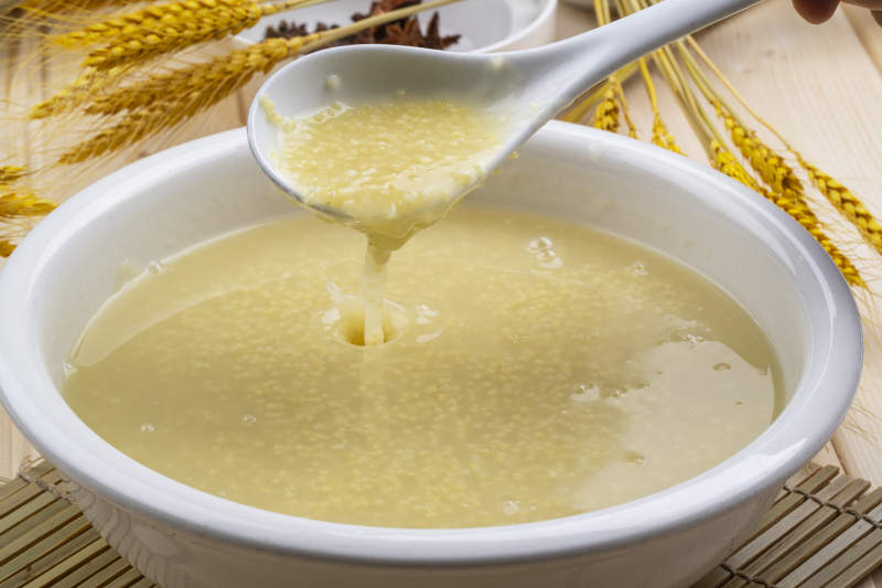 白色瓷盆装的黄金奶汤小米粥图片