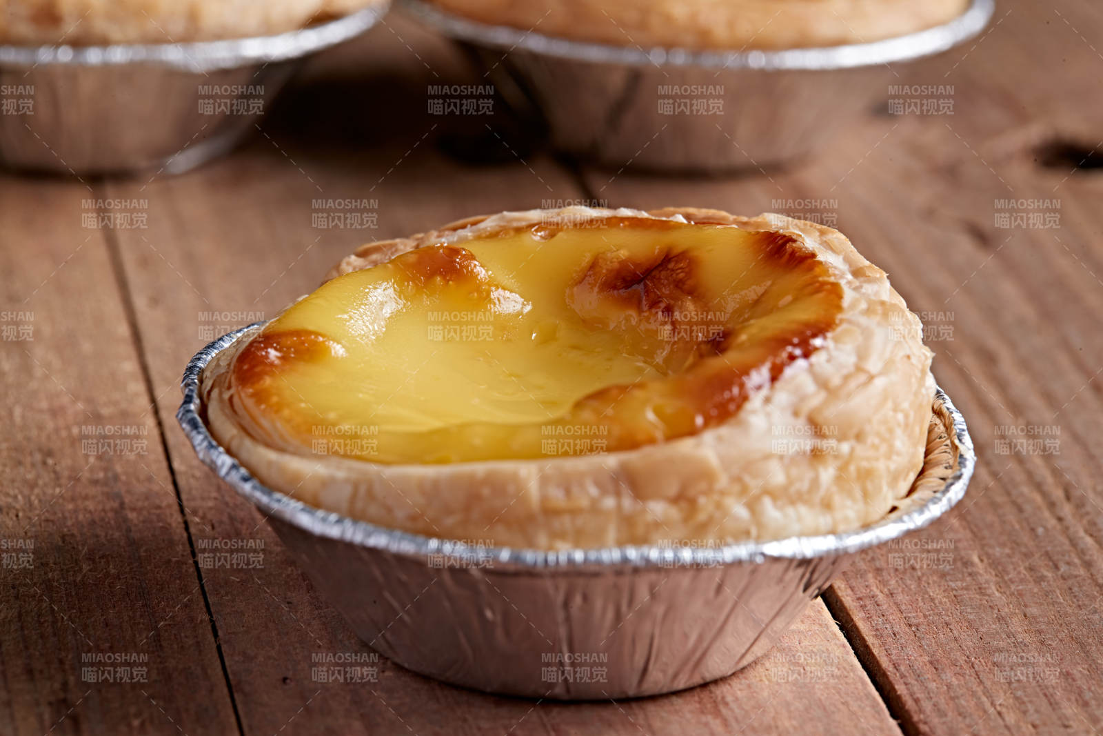 木板上的香烤葡式蛋挞图片