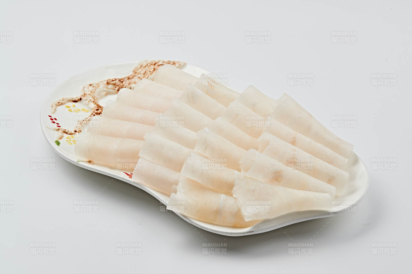 白色瓷盘装的顶级俄罗斯银鳕鱼切片图片