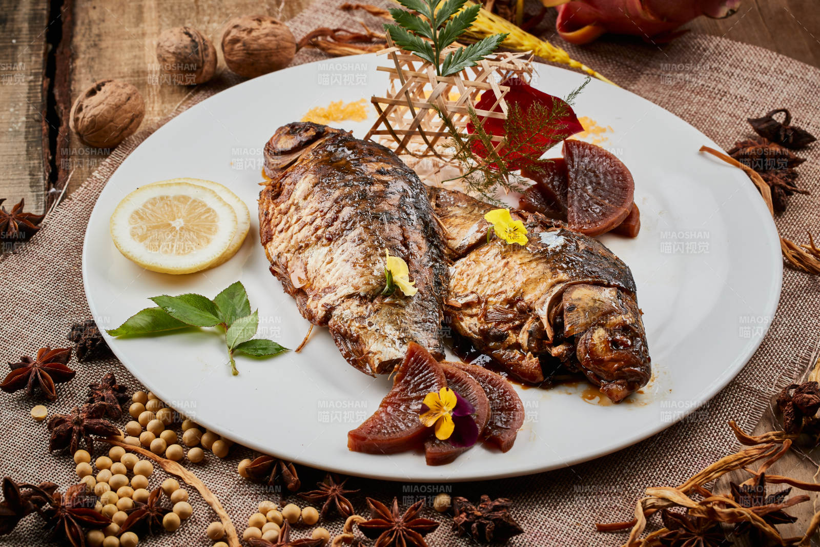 陈旧木板上的圆瓷盘装的家炖香酥鲫鱼图片