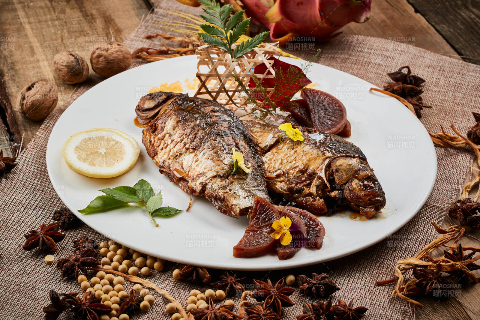 陈旧木板上的圆瓷盘装的家炖香酥鲫鱼图片