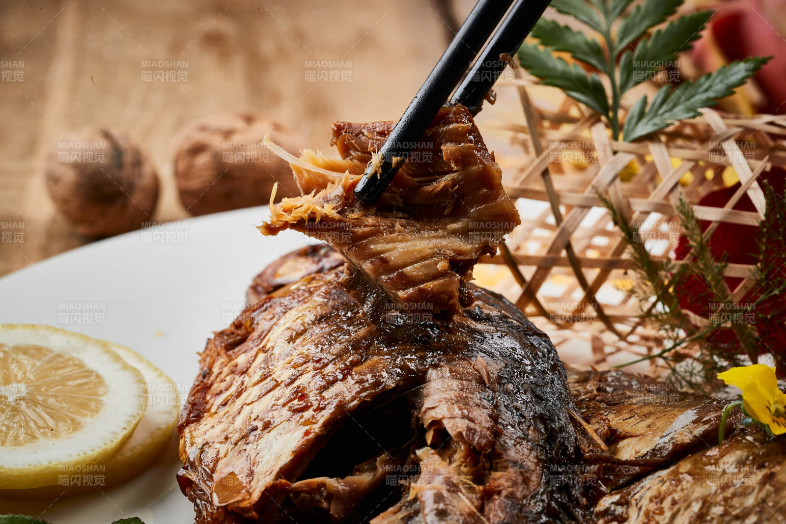 陈旧木板上的圆瓷盘装的家炖香酥鲫鱼图片