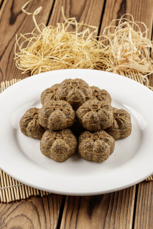 圆形白色瓷盘装的杂粮黑豆馍图片