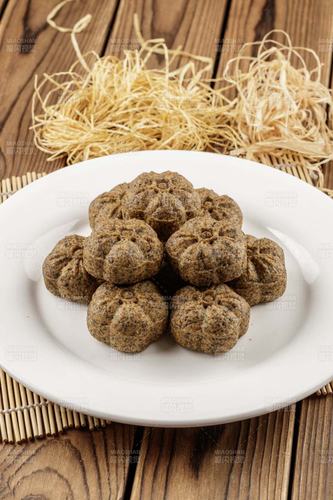 圆形白色瓷盘装的杂粮黑豆馍图片