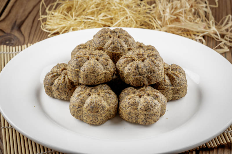 圆形白色瓷盘装的杂粮黑豆馍图片