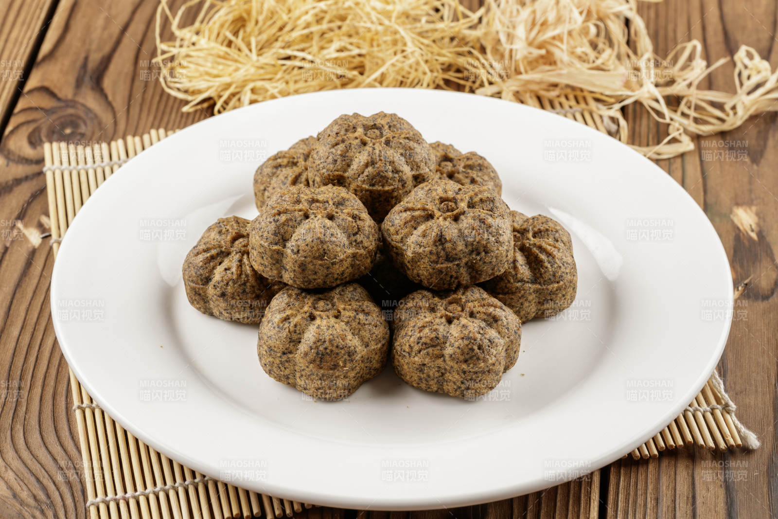 圆形白色瓷盘装的杂粮黑豆馍图片