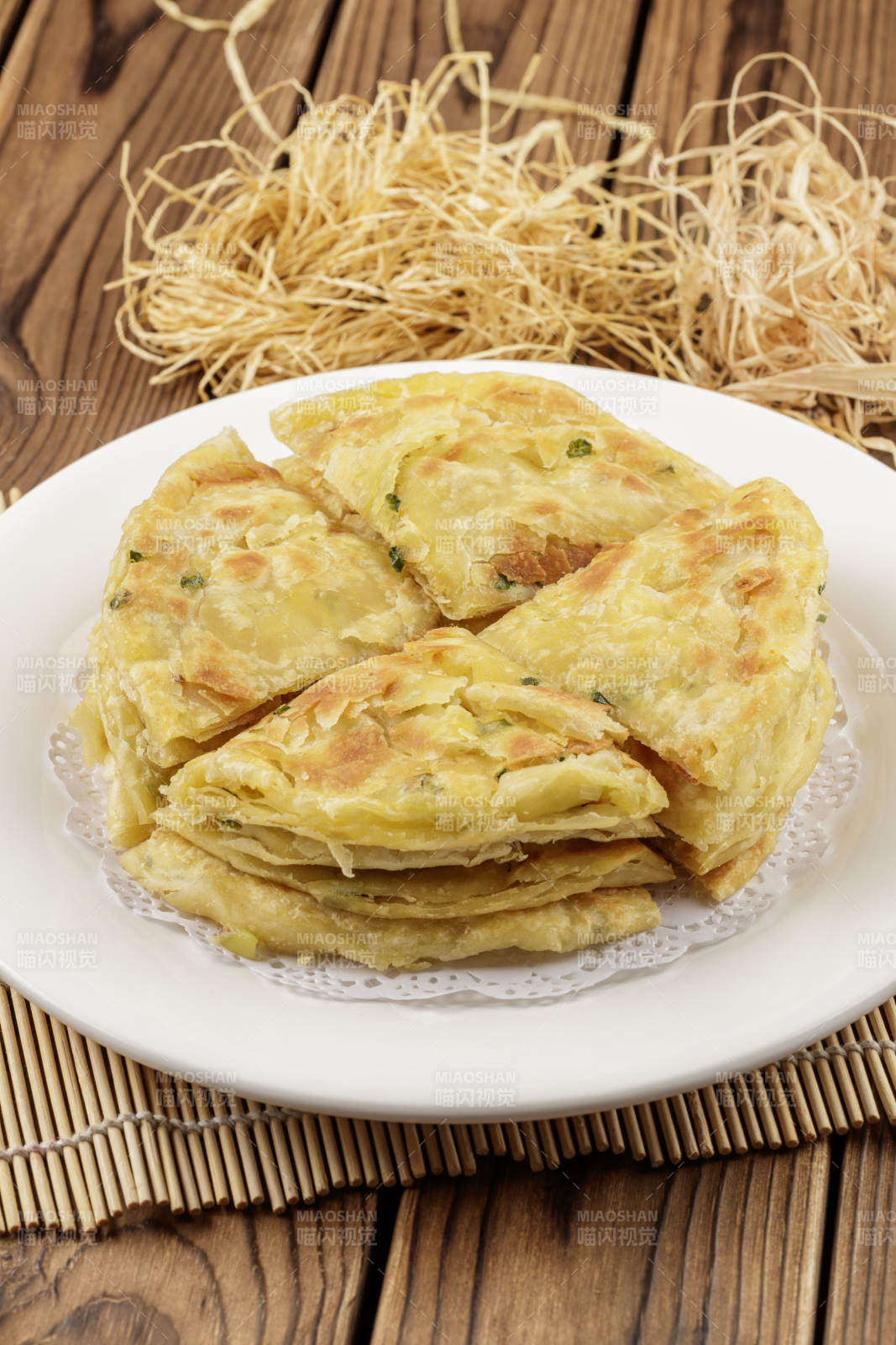 圆形白色瓷盘装的葱花饼图片