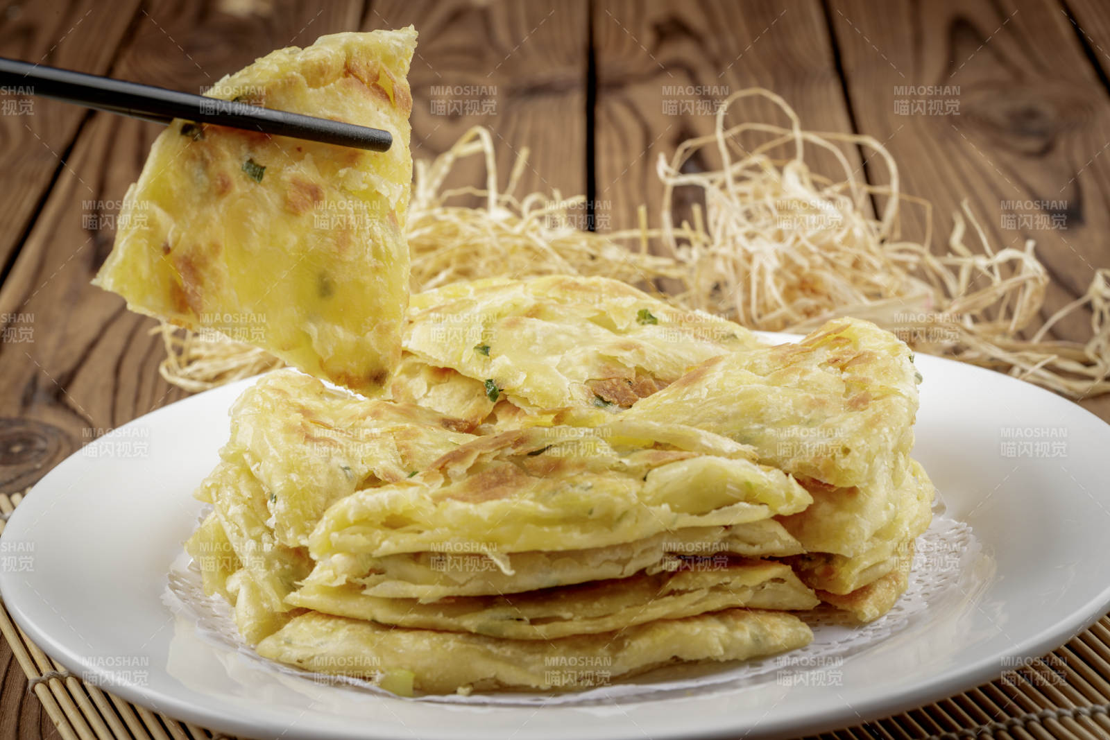 圆形白色瓷盘装的葱花饼图片